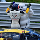 Driver Oliver Gavin high-fives Bibendum next to the race-winning No. 4 Corvette. Photo credit: IMSA